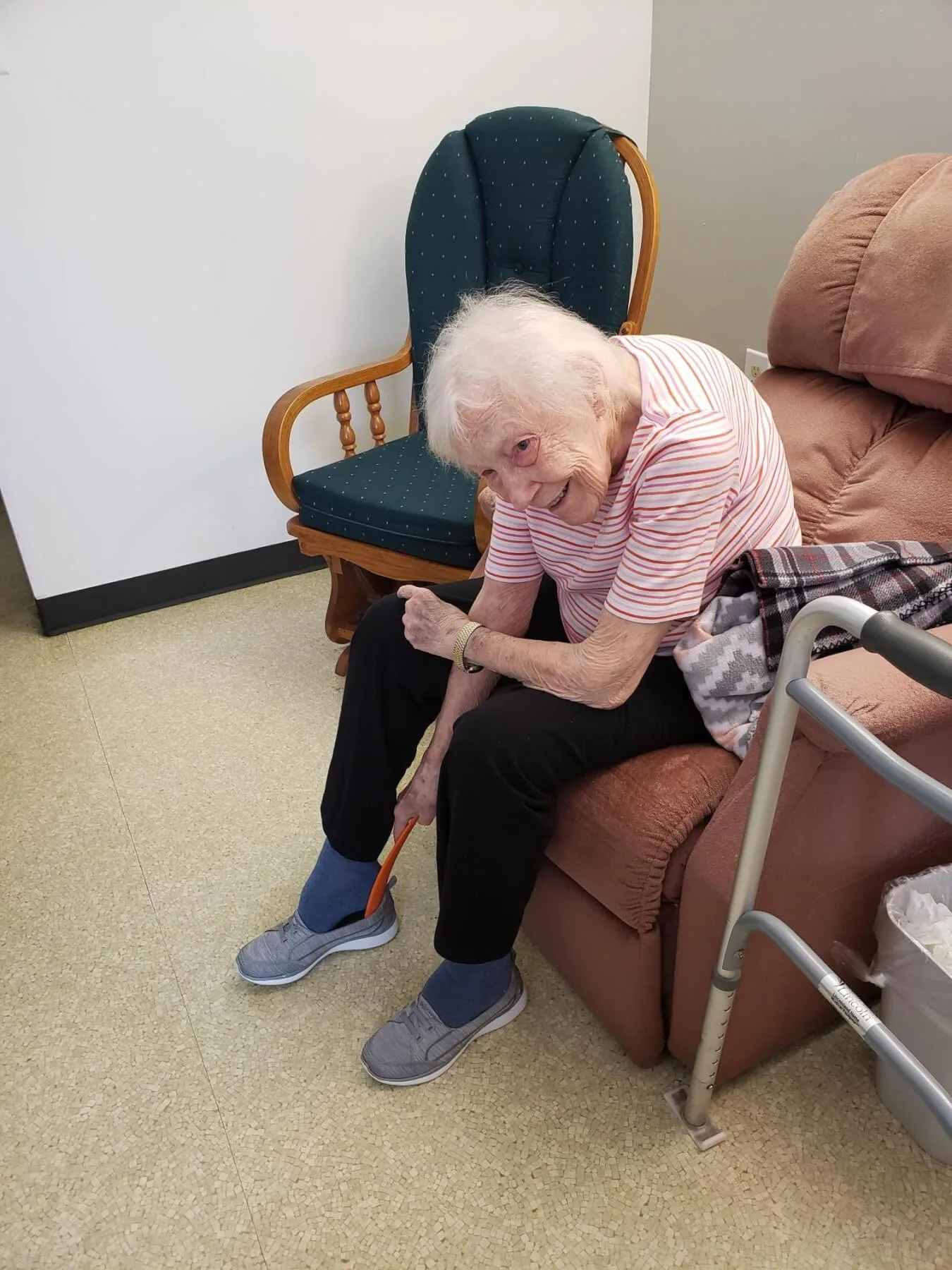 Woman using a 3D printed shoe horn to assist with her shoe