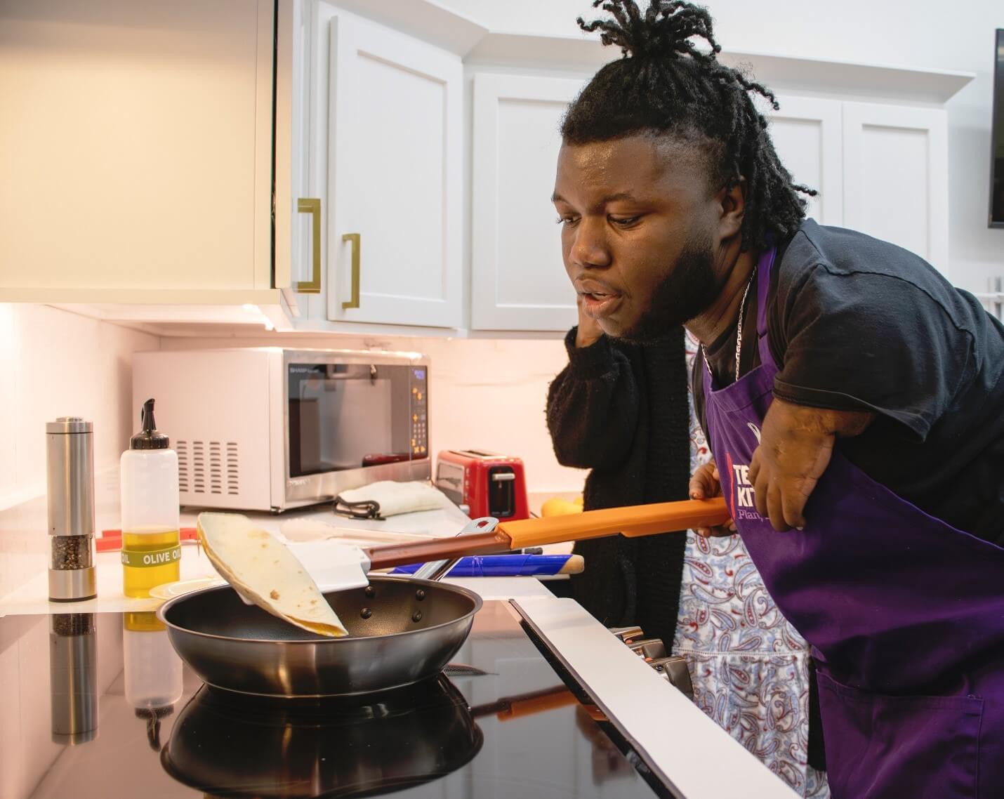 Person using long handled cooking assist