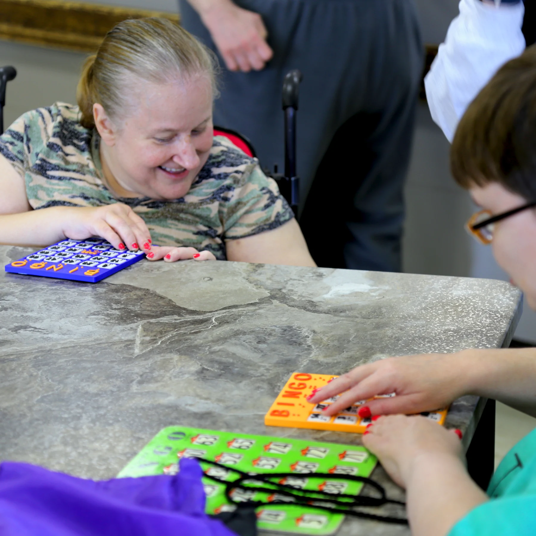 Two women using braille bingo board