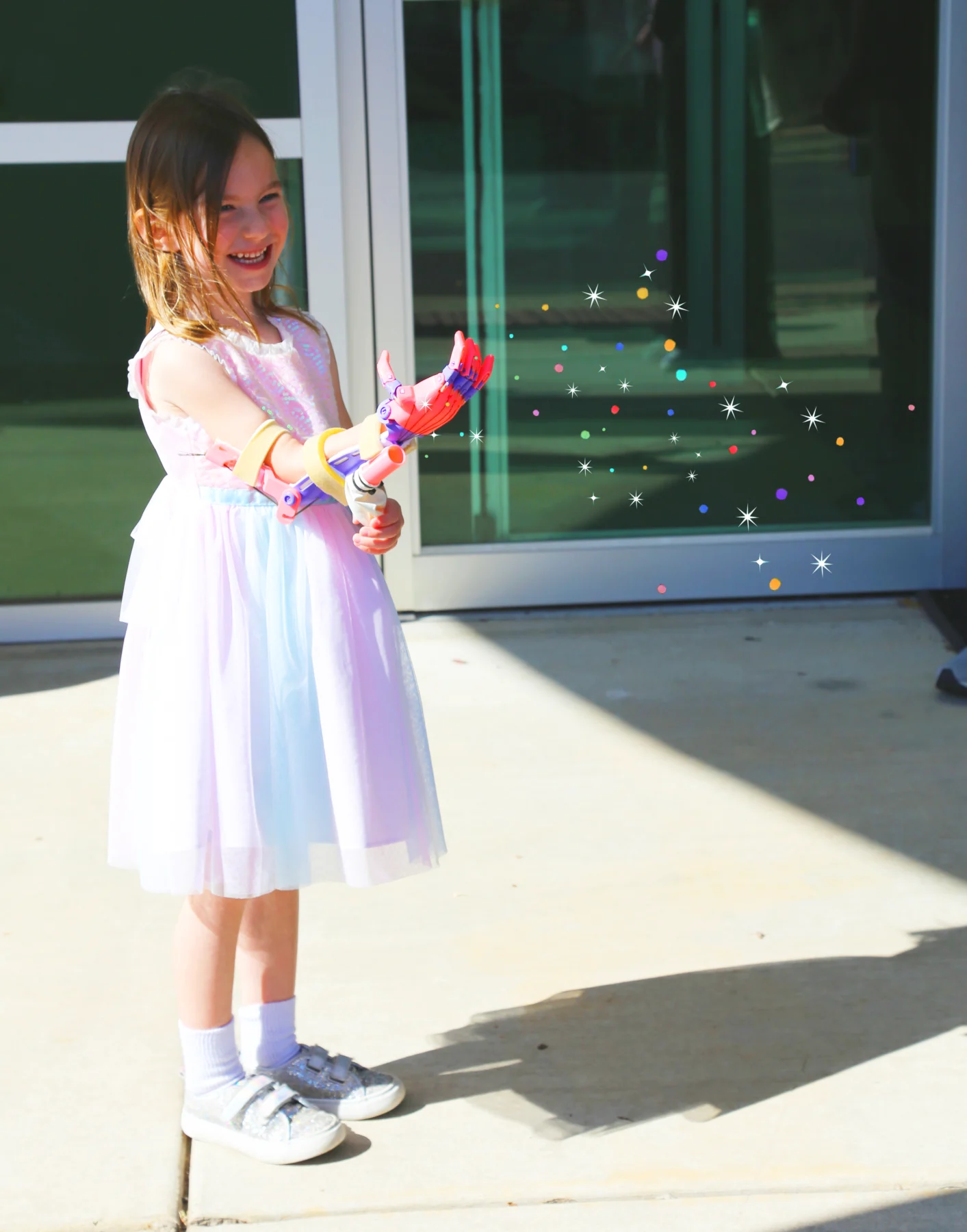 Mackenzie using prosthetic arm with a glitter shooter attached