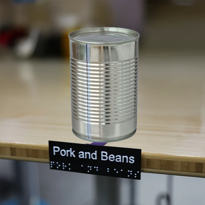 Tin can with braille shelf label, labeled pork and beans