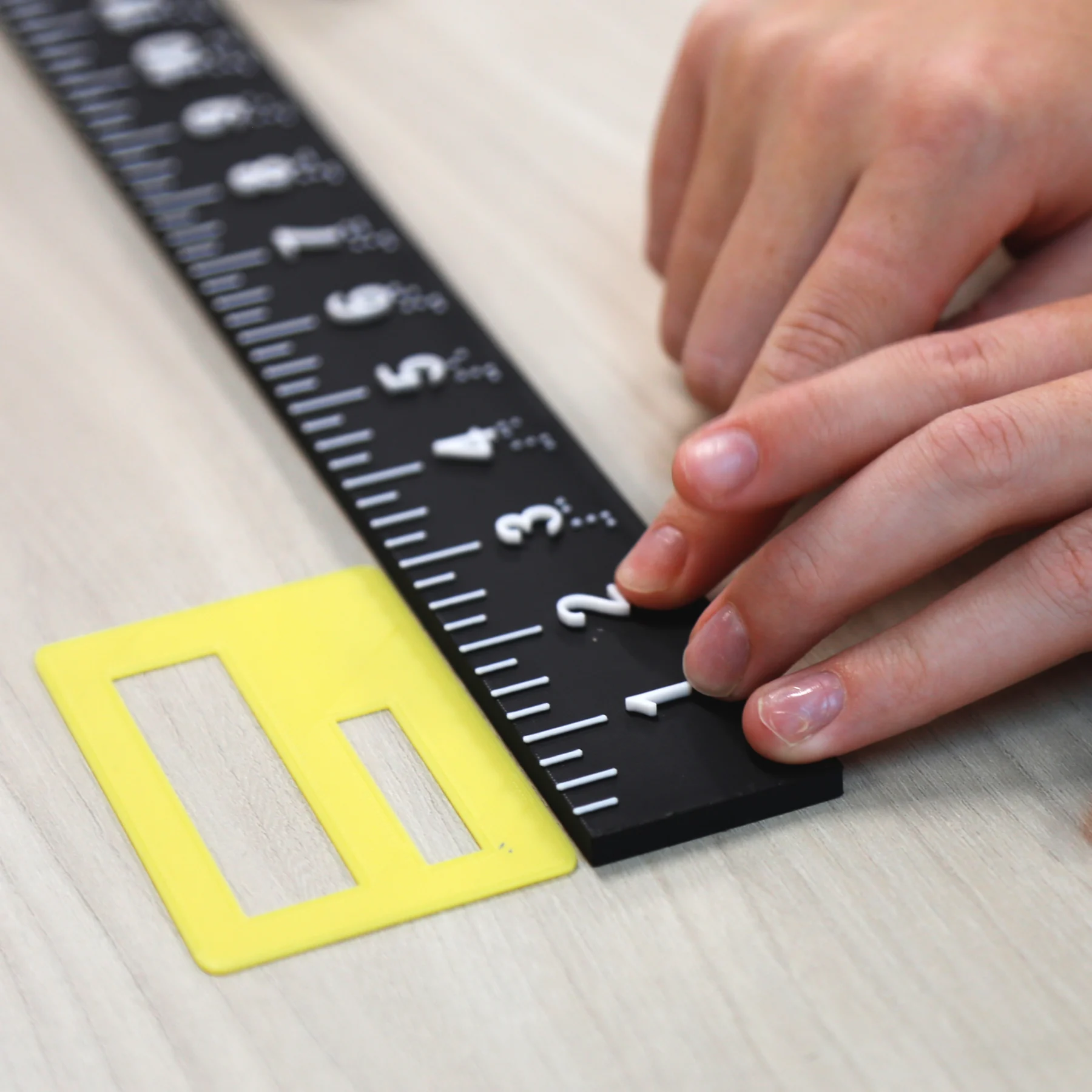 Braille raised ruler in use measuring a signature guide