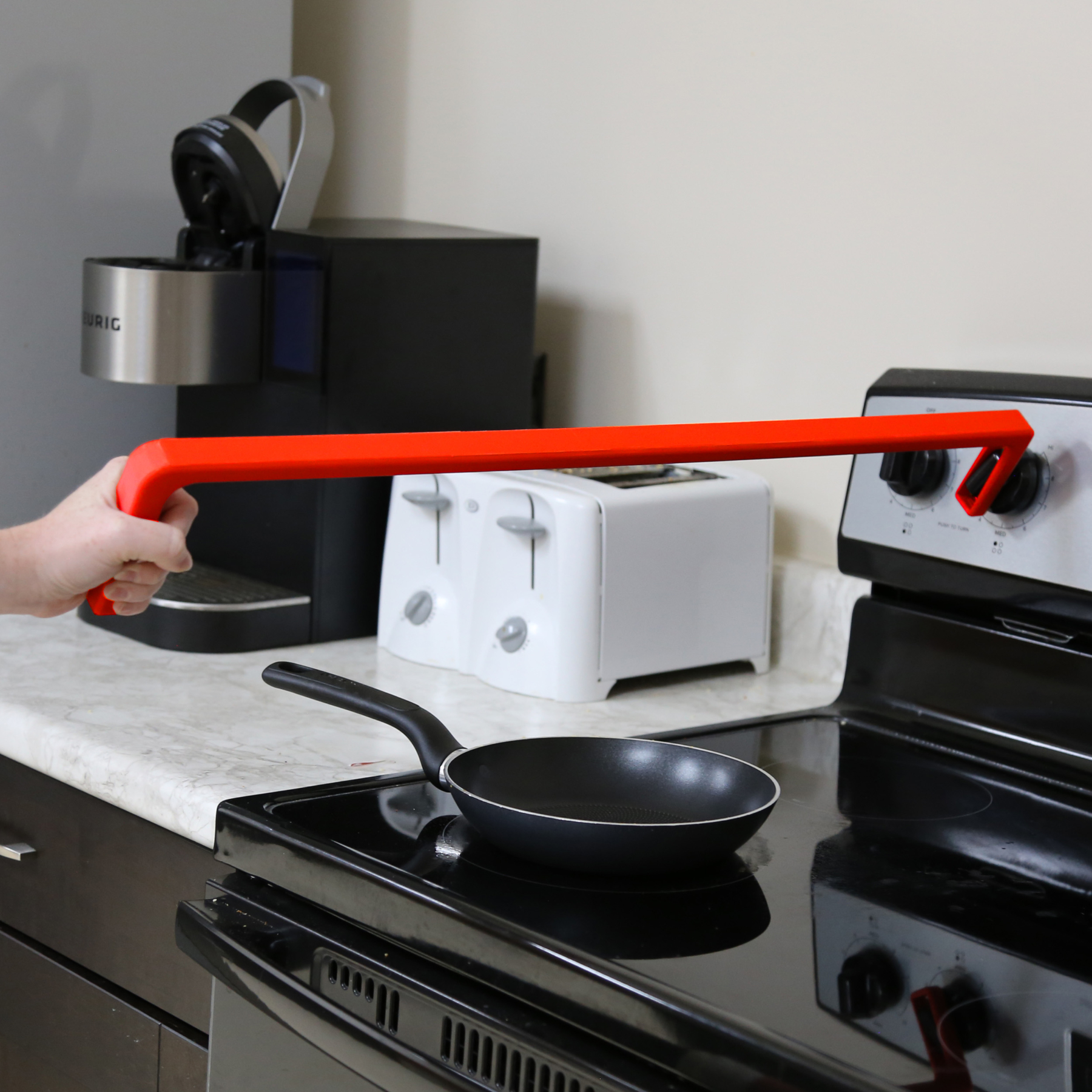Stove knob Reacher in use adjusting temperature