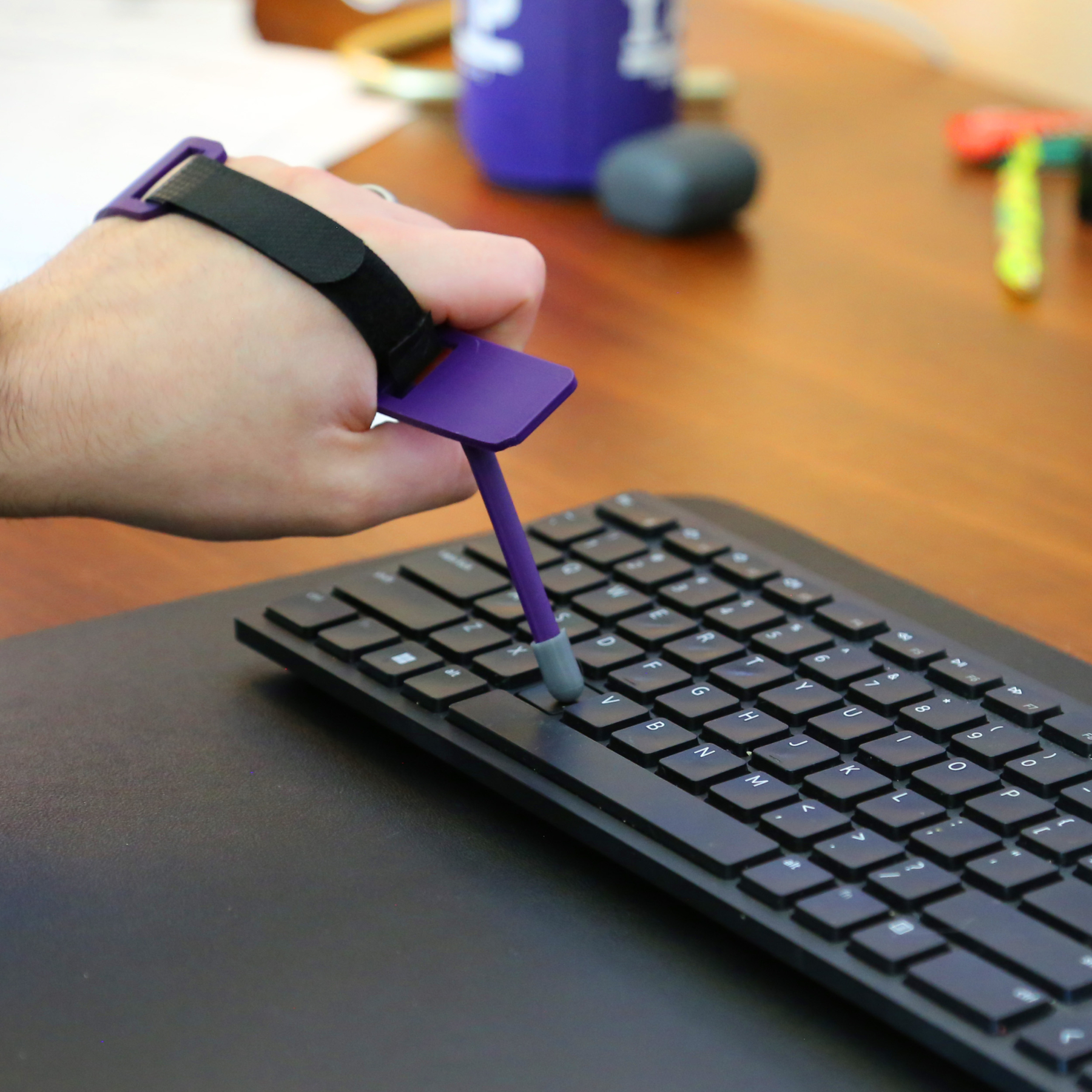 Typing stick with velcro strap using a keyboard