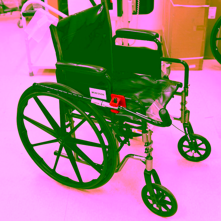 Wheelchair with attached clip to hold a cane