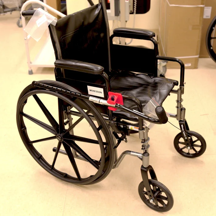 Wheelchair with attached clip to hold a cane