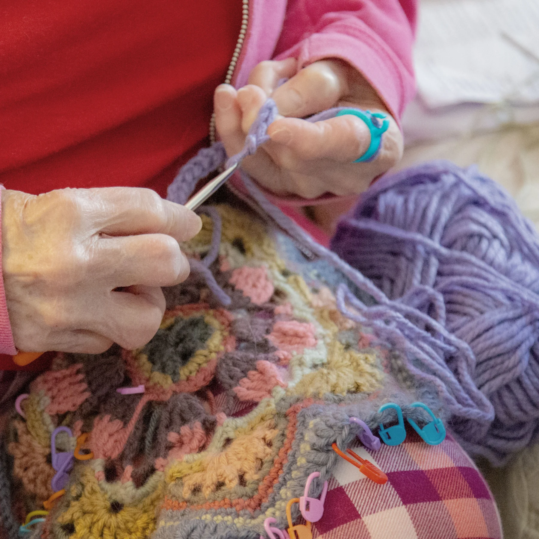 Woman crocheting while using a crochet ring to hold tension