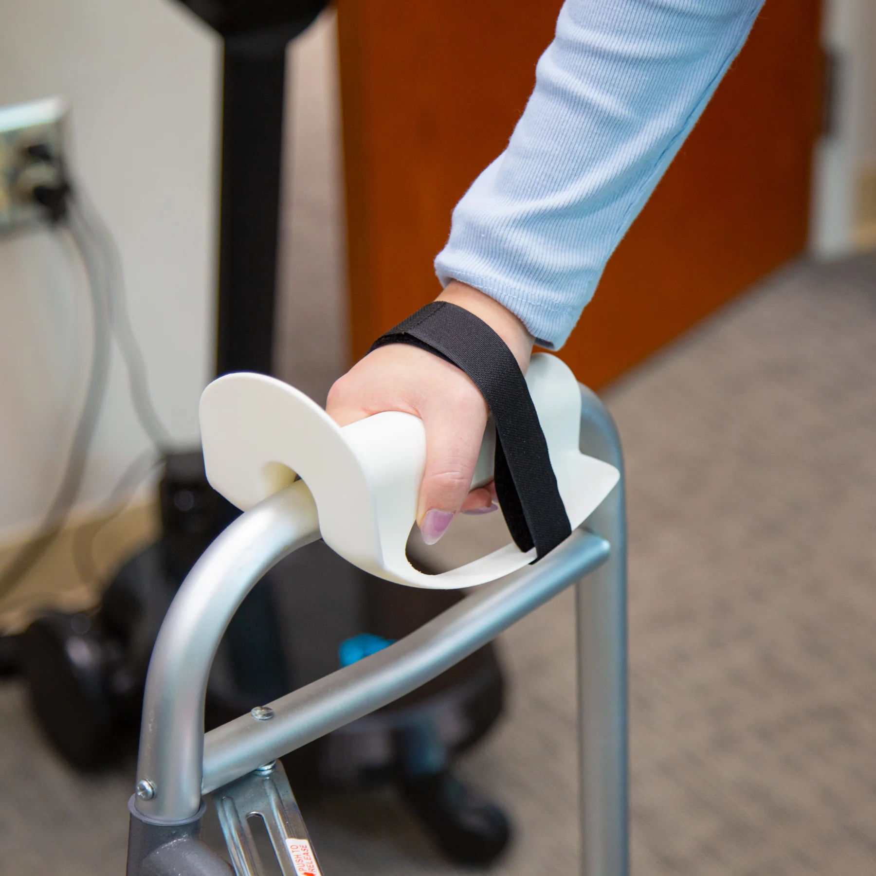 Lady gripping walker handle cuff secured to walker