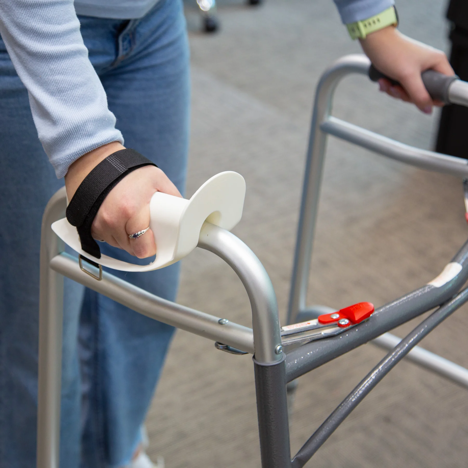 Person using Walker Handle Cuff strapped to walker