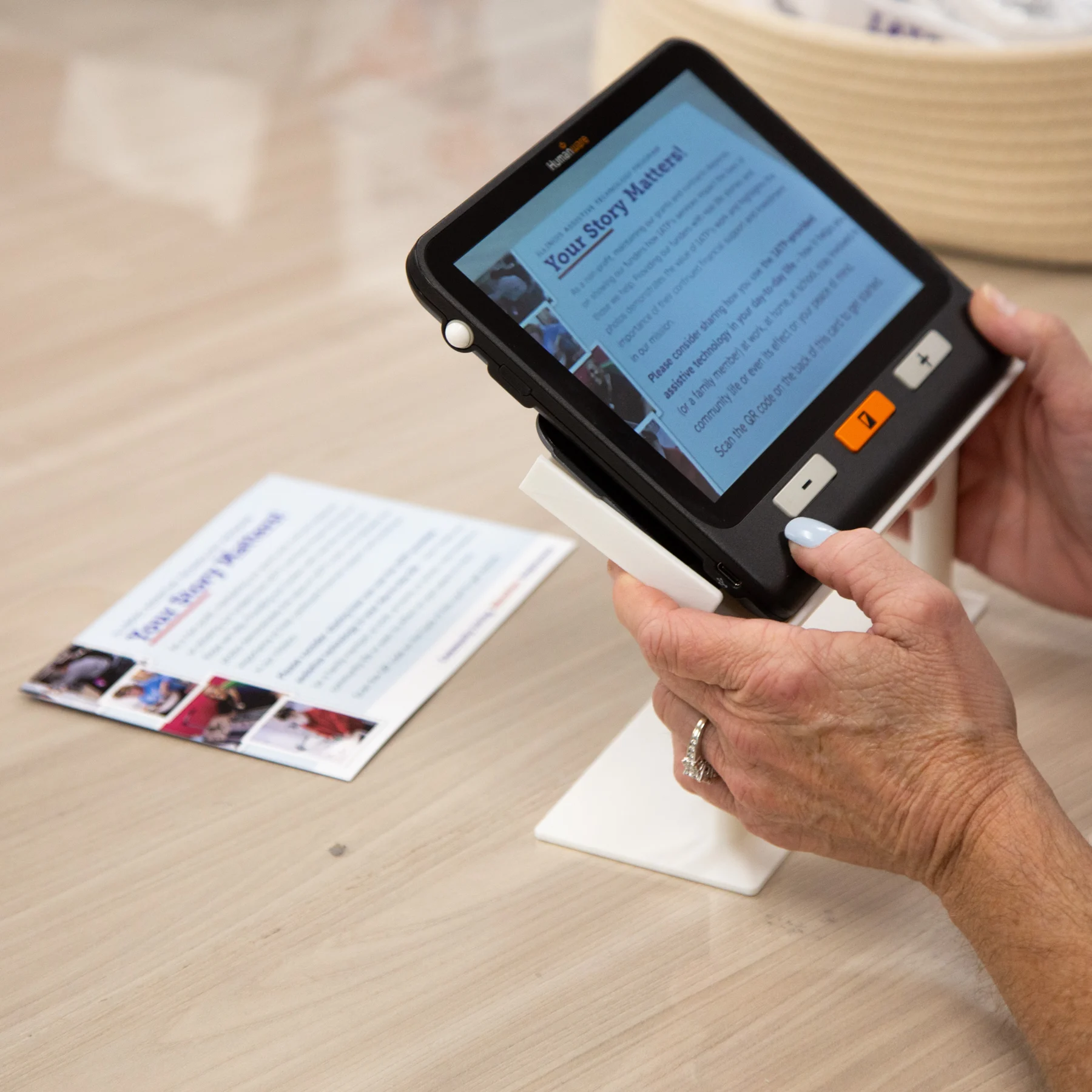 Woman using Explore 8 Stand to magnify info letter